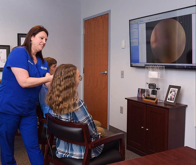 A Physical Inspection Allows Our Experts To Thoroughly Understand The Situation Earwax removal expert performing ear inspection prior to earwax removal procedure